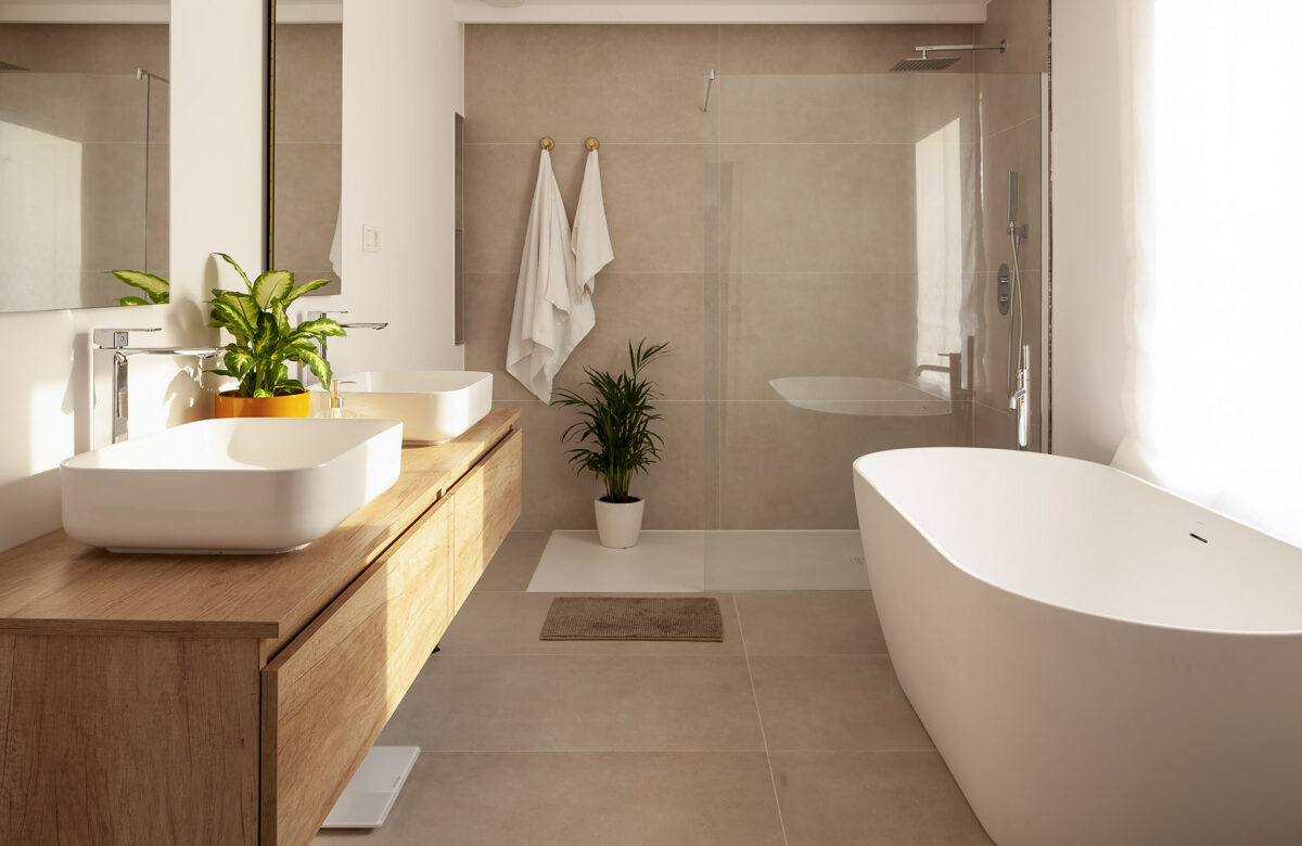 Bany modern amb banyera exempta i acabats naturals en habitatge sostenible