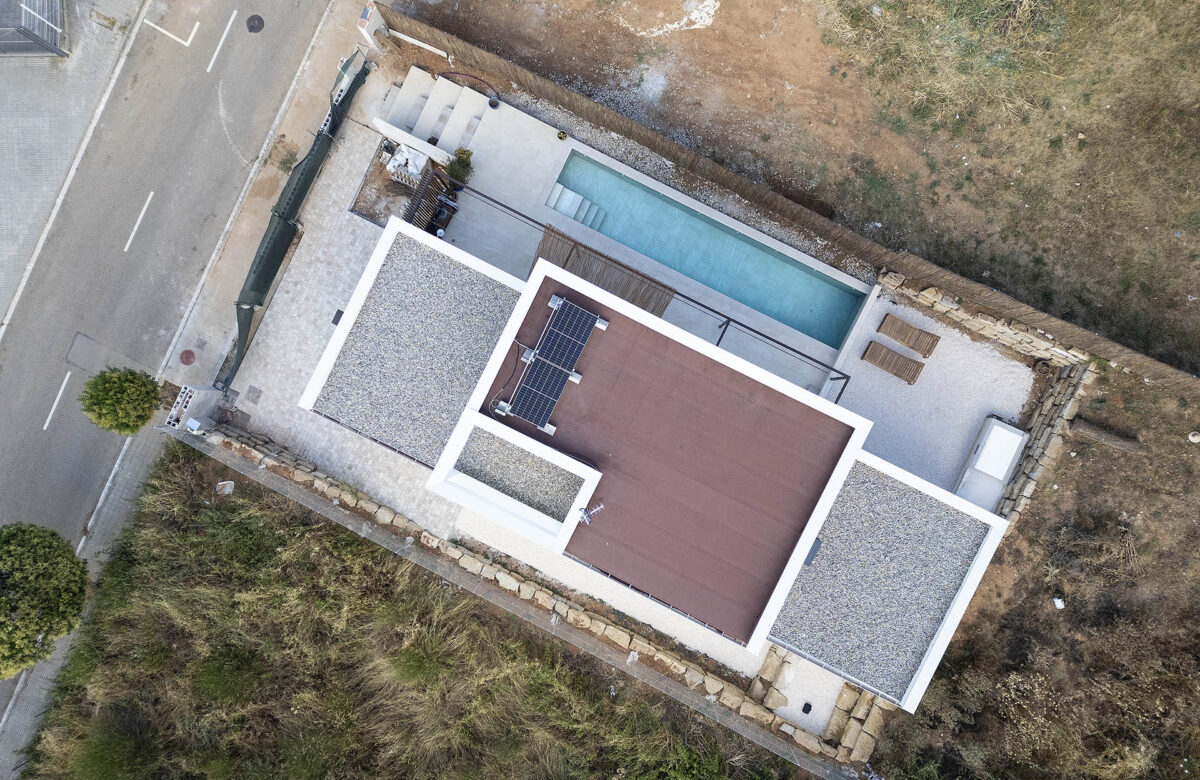 Vista aèria d’una casa sostenible amb piscina i coberta eficient energèticament